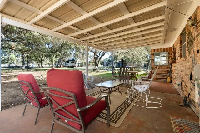 a view of a patio with table and chairs and couches with wooden floor