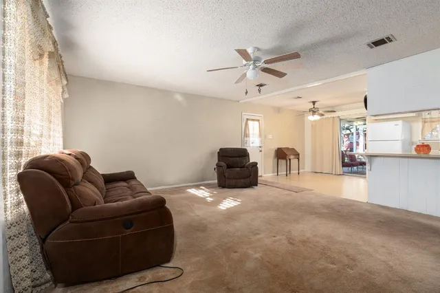 a living room with furniture and kitchen view