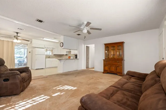 a view of a livingroom with a ceiling fan and a window