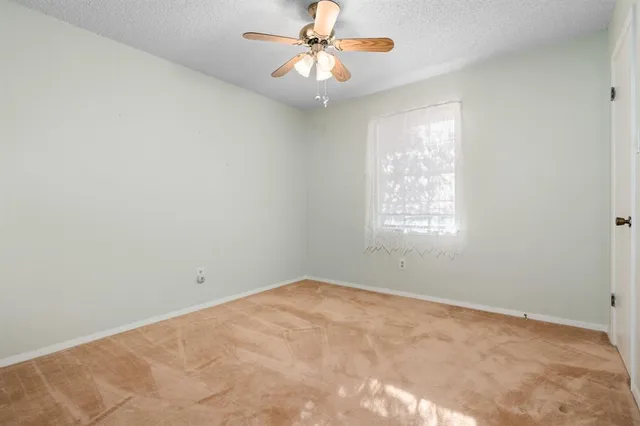 an empty room with a chandelier fan