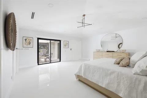 a bedroom with a bed mirror and window