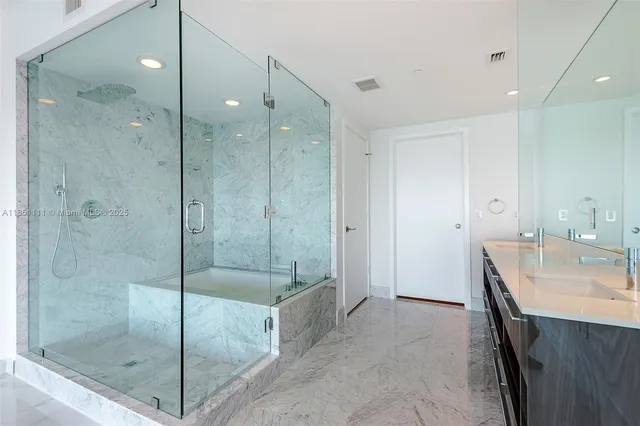 a bathroom with a shower a sink and mirror