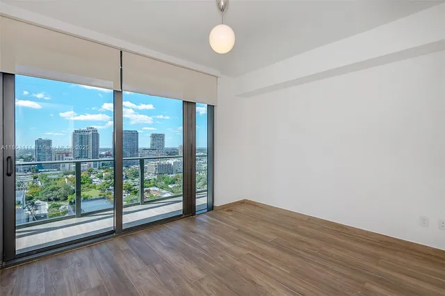 a view of a room with wooden floor and large window