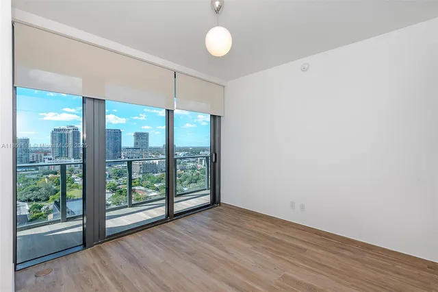 a view of a room with wooden floor and large window