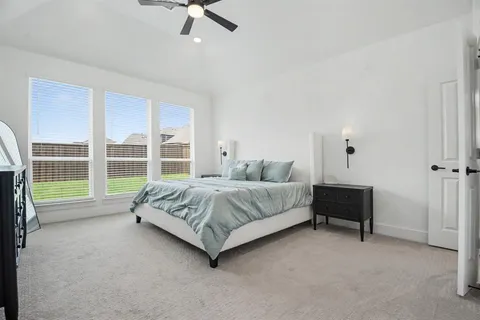 a spacious bedroom with a bed and a large window