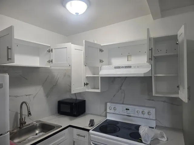 a kitchen with white cabinets and white appliances