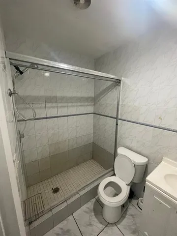 a bathroom with a toilet and a shower