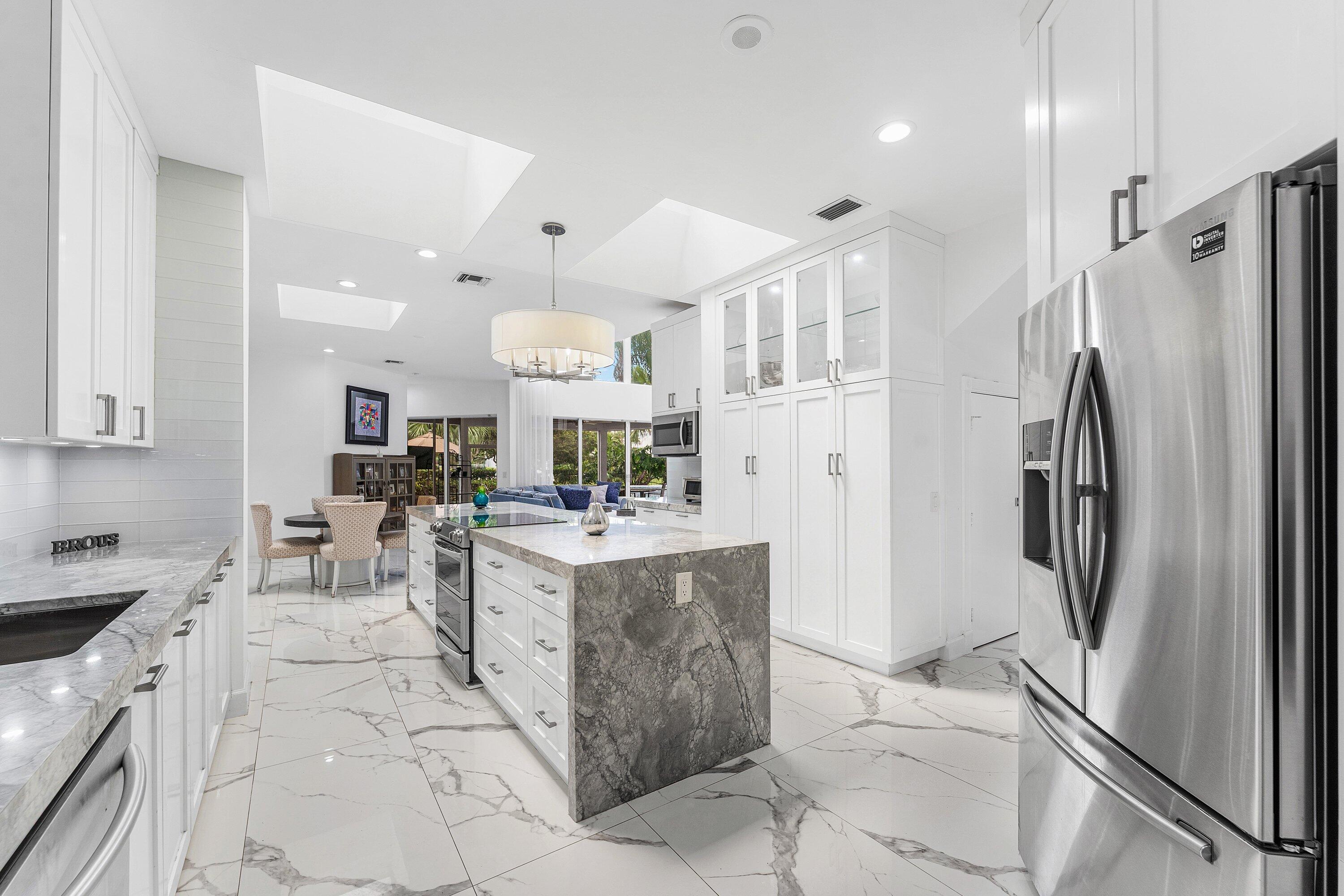 5863 Waterford Boca Raton, FL 33496 - Photo 11 of 90 a kitchen with stainless steel appliances a refrigerator a sink a stove a microwave a center island and furniture