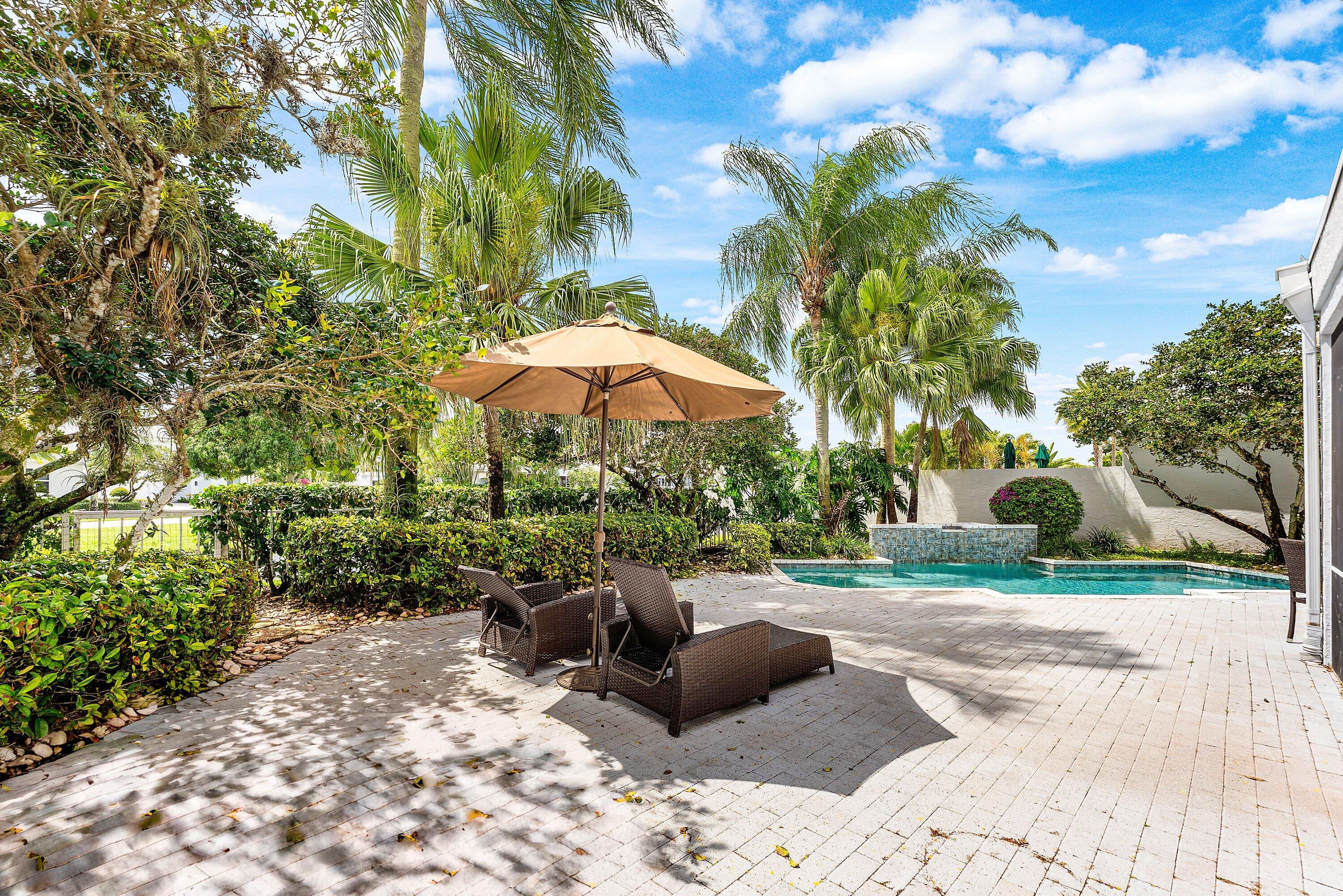 5863 Waterford Boca Raton, FL 33496 - Photo 34 of 90 a view of a backyard with chairs under an umbrella