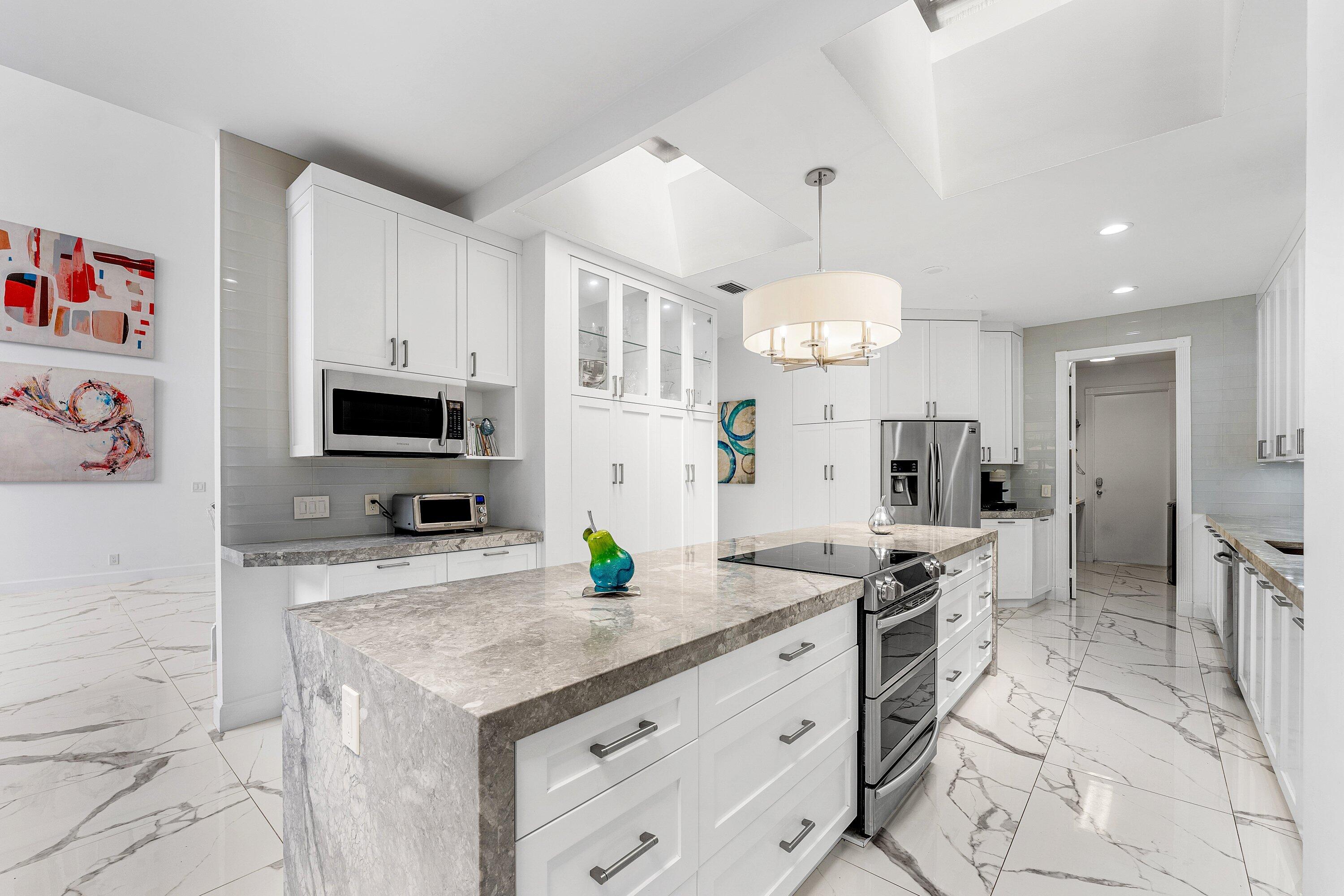 5863 Waterford Boca Raton, FL 33496 - Photo 10 of 90 a kitchen with stainless steel appliances kitchen island granite countertop a stove a sink and a refrigerator