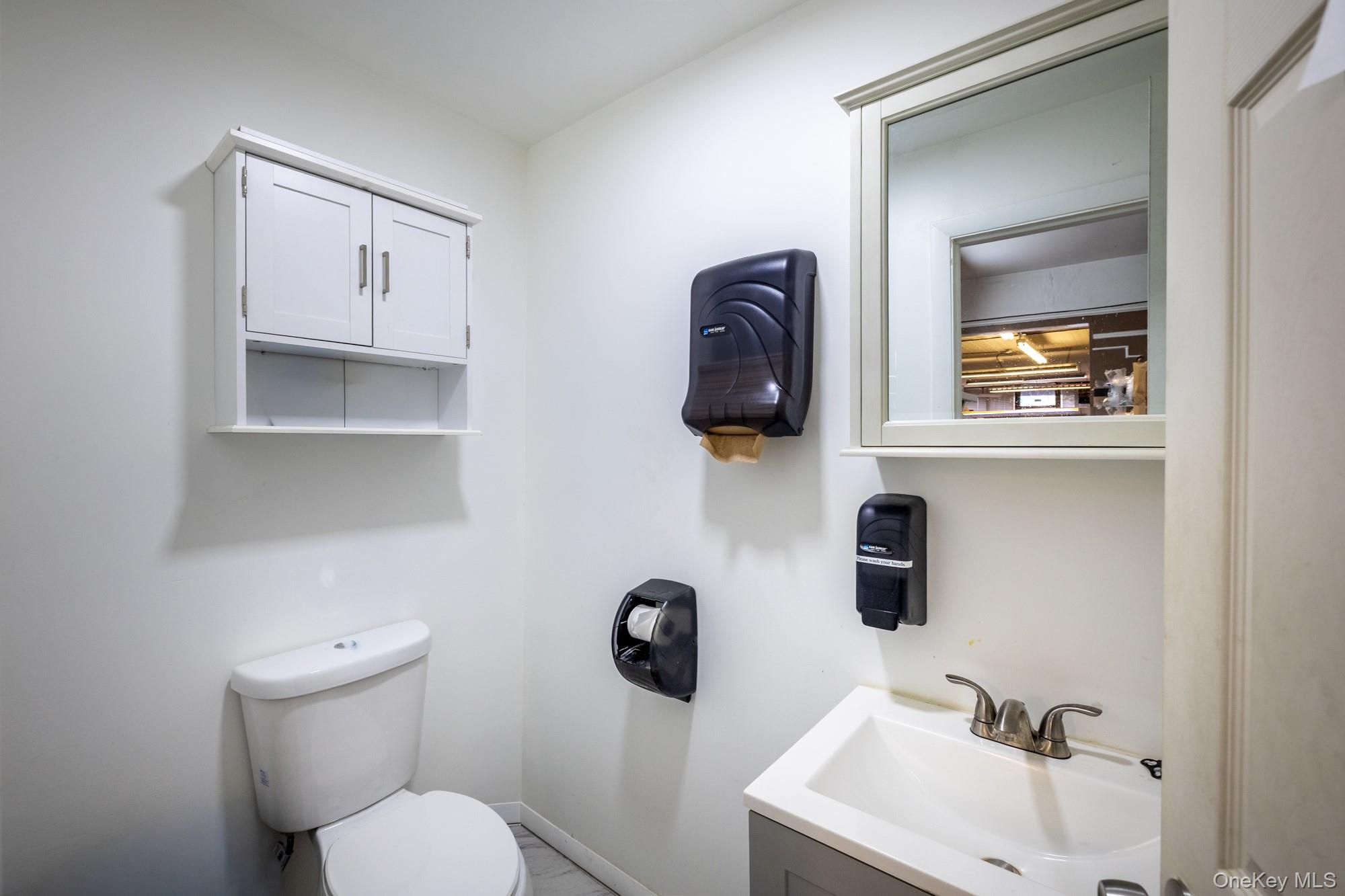 677 Van Nest Avenue Bronx, NY 10462 - Photo 11 of 49 a bathroom with a toilet sink and mirror