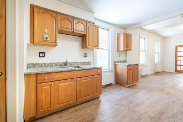 a kitchen with stainless steel appliances granite countertop a stove a sink and a refrigerator with wooden floors