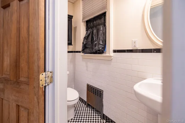 a bathroom with a toilet a sink and a mirror