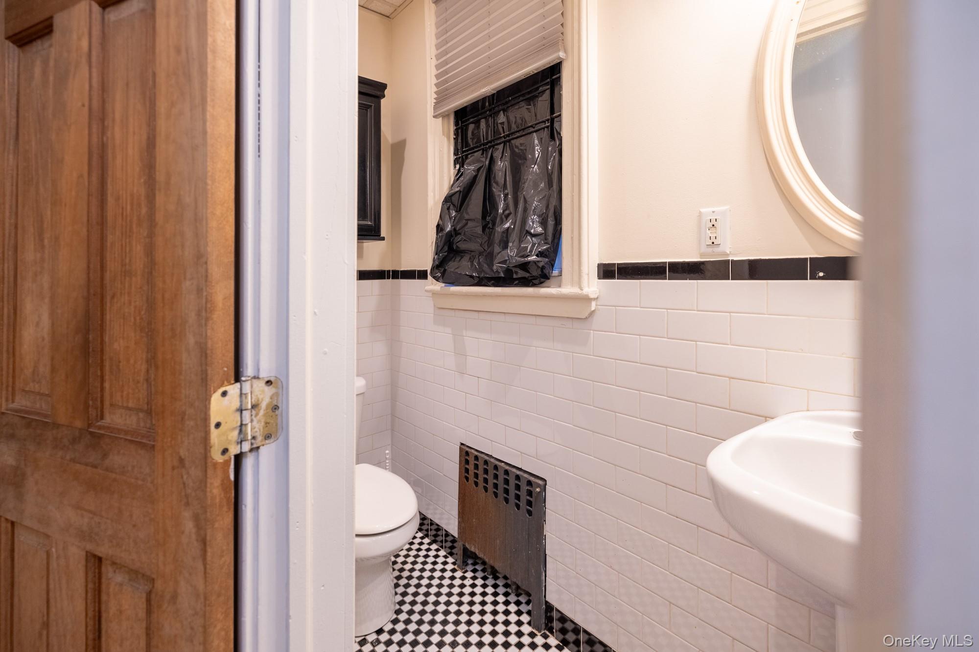 677 Van Nest Avenue Bronx, NY 10462 - Photo 18 of 49 a bathroom with a toilet a sink and a mirror