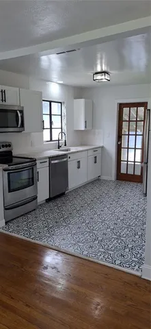 a large white kitchen with cabinets