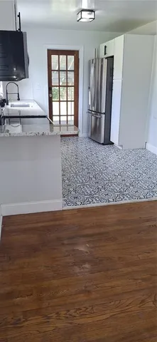 a view of a kitchen with wooden floor and electronic appliances