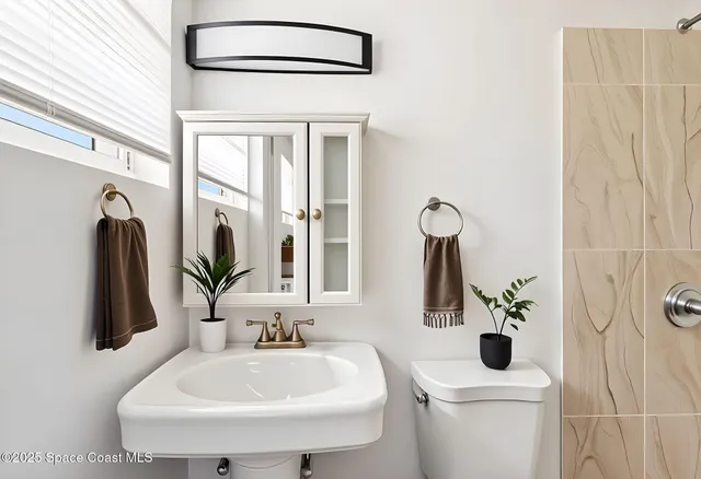 a bathroom with a sink a toilet and mirror