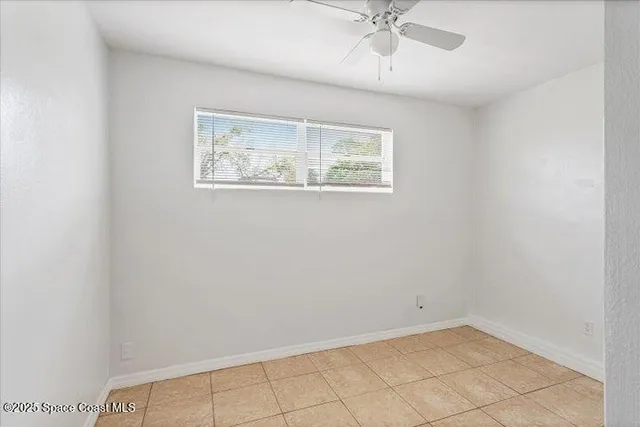 an empty room with a window and a ceiling fan