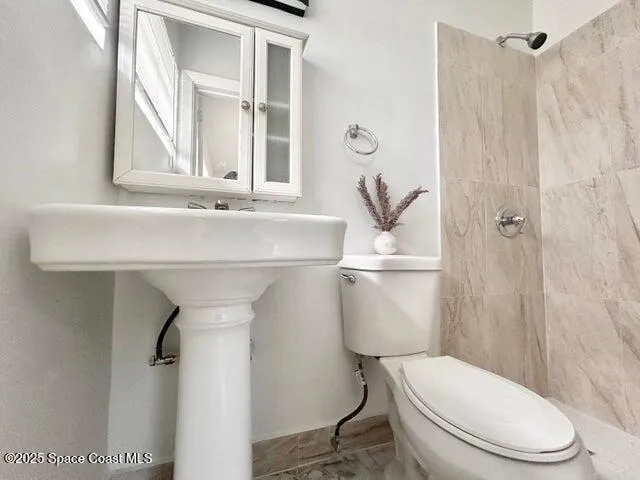 a white toilet sitting next to a bathroom sink
