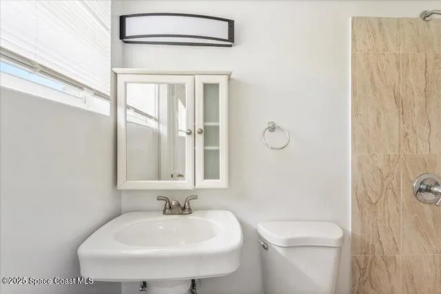 a bathroom with a sink a toilet and a mirror