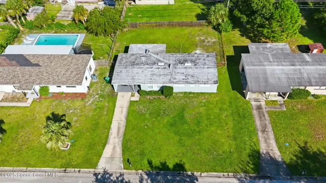 an aerial view of a house with a yard