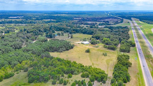 an aerial view of residential houses with outdoor space and trees
