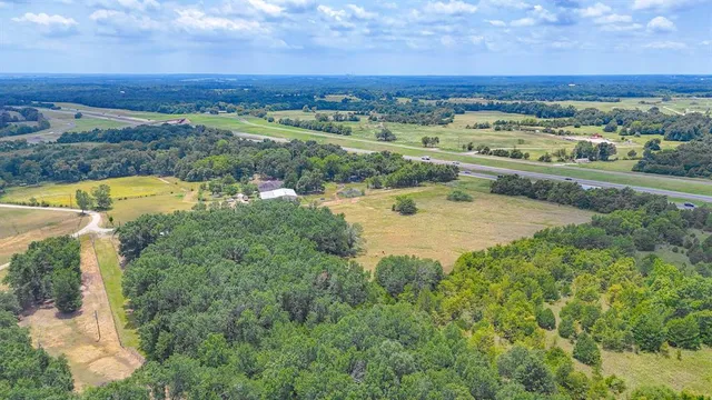 an aerial view of residential houses with outdoor space and trees