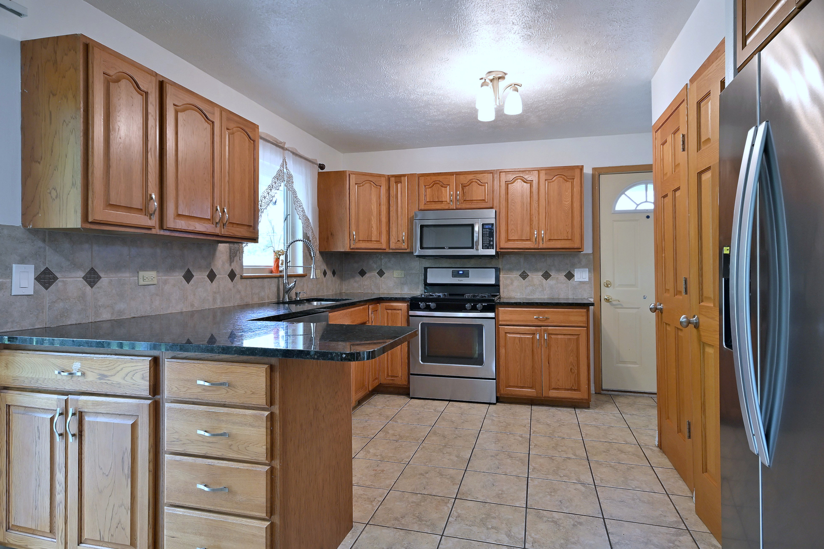 20564 Elizabeth Avenue Prairie View, IL 60089 - Photo 11 of 40 a kitchen with stainless steel appliances granite countertop wooden cabinets a stove top oven a sink and dishwasher