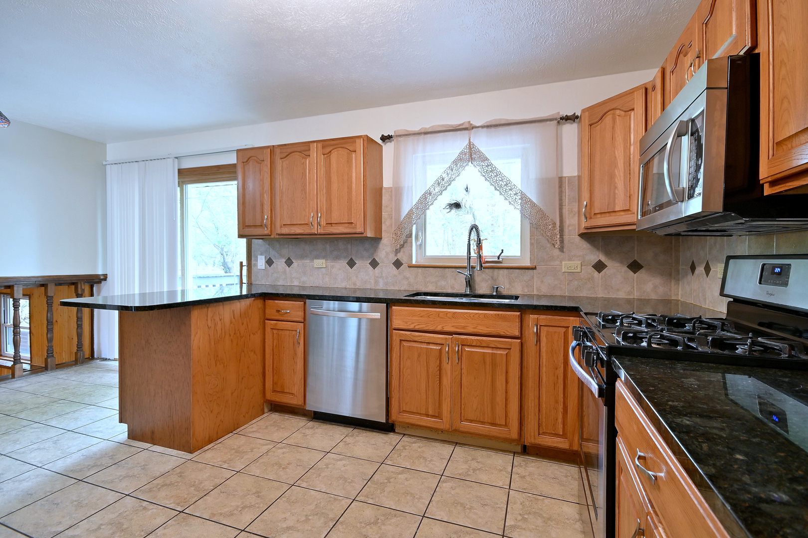 20564 Elizabeth Avenue Prairie View, IL 60089 - Photo 12 of 40 a kitchen with stainless steel appliances granite countertop a stove a sink and a microwave