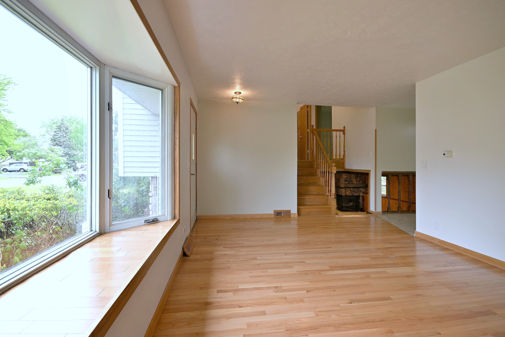 20564 Elizabeth Avenue Prairie View, IL 60089 - Photo 9 of 40 a view of an empty room with a window and wooden floor