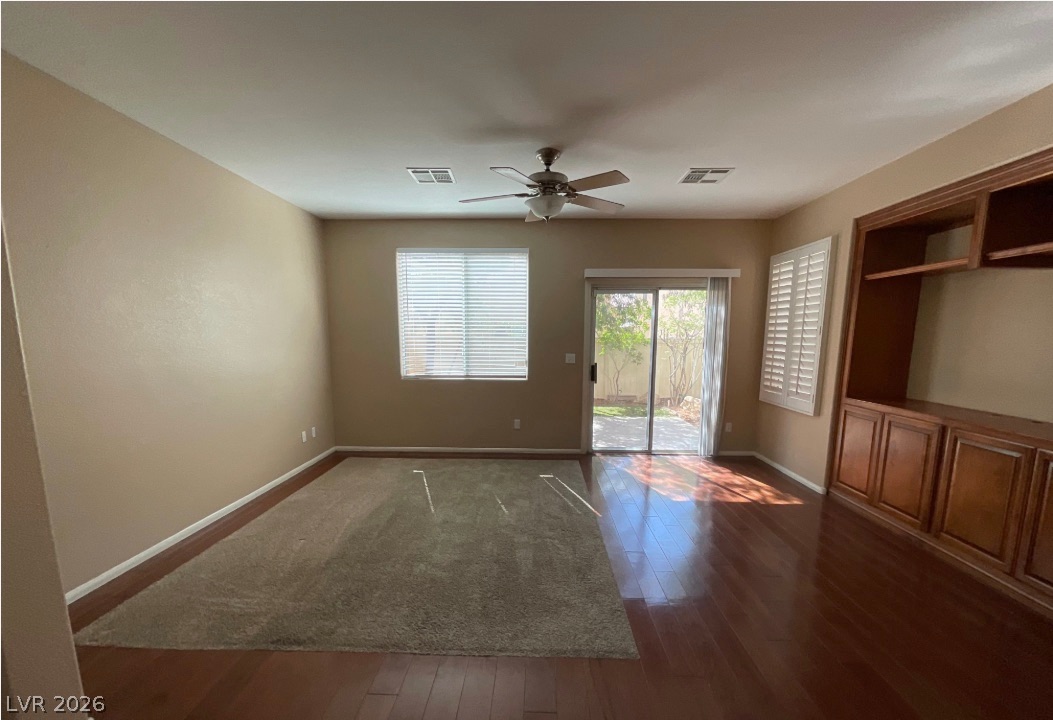10841 Paradise Road Henderson, NV 89052 - Photo 6 of 35 Sun-filled room boasts beautiful hardwood flooring and convenient backyard access.