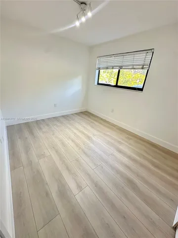 an empty room with windows and mirror