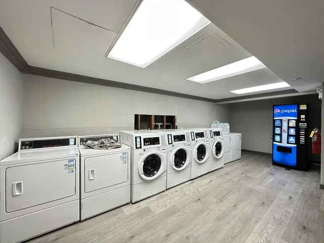 a kitchen with a stove and white cabinets with wooden floor