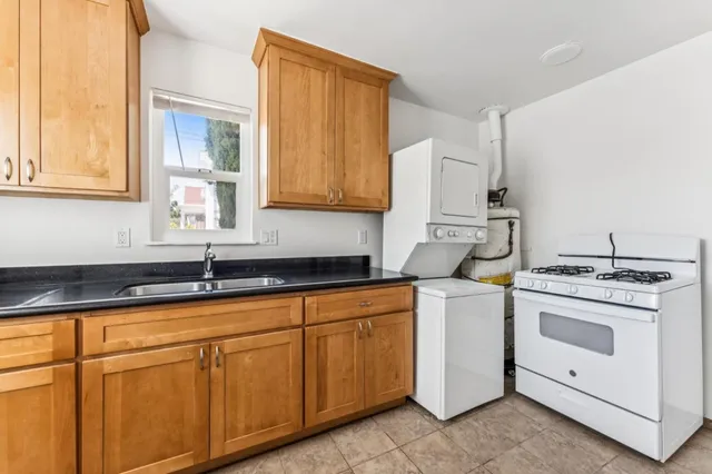 a kitchen with granite countertop white cabinets and white appliances