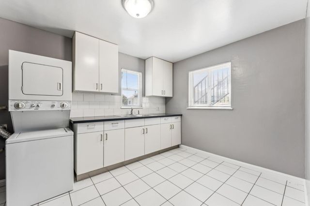 a kitchen with granite countertop white cabinets and white appliances