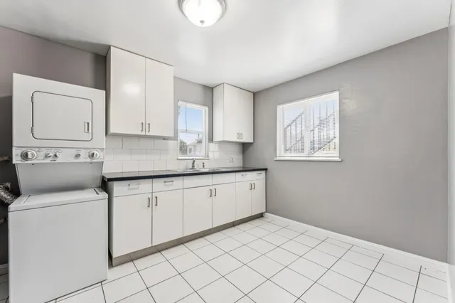 a kitchen with granite countertop white cabinets and white appliances