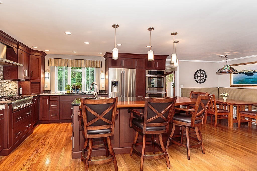 17 Dennett Road Winchester, MA 01890 - Photo 11 of 41 a kitchen with stainless steel appliances kitchen island granite countertop a table chairs and a refrigerator