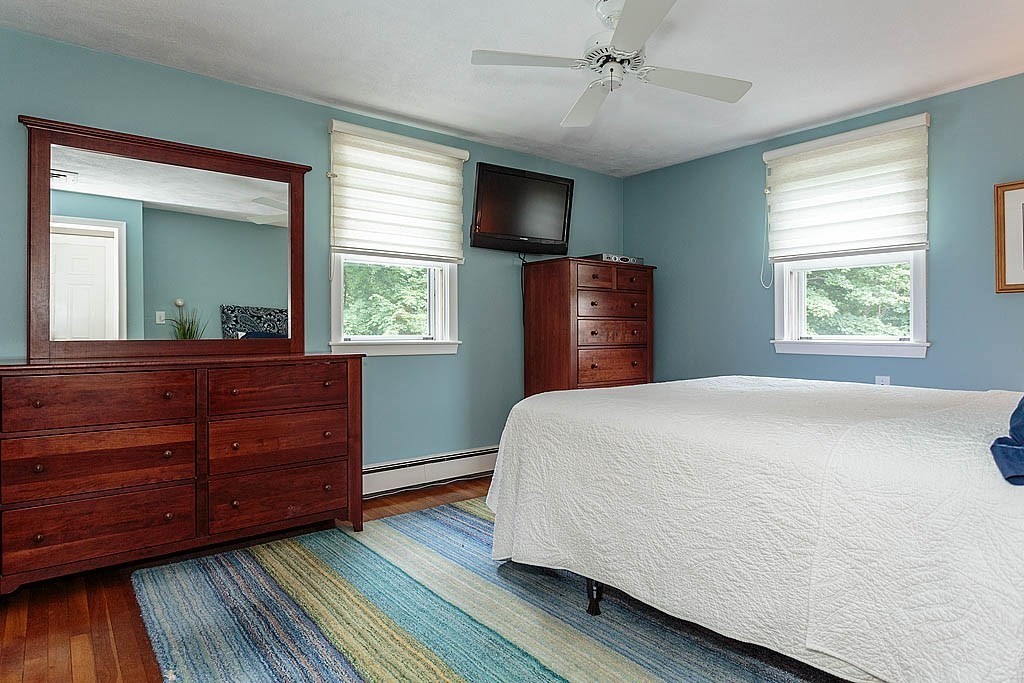 17 Dennett Road Winchester, MA 01890 - Photo 16 of 41 a bedroom with a bed and a large mirror on dresser with wooden floor