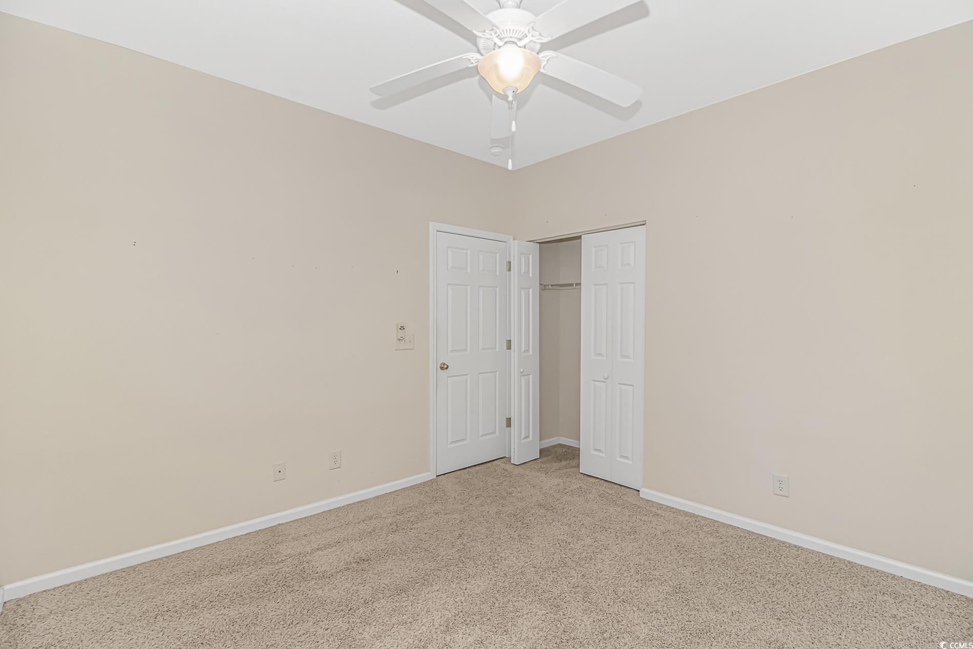 139 Chenoa Drive, Unit D Murrells Inlet, SC 29576 - Photo 17 of 34 Unfurnished bedroom featuring carpet floors, a closet, and a ceiling fan