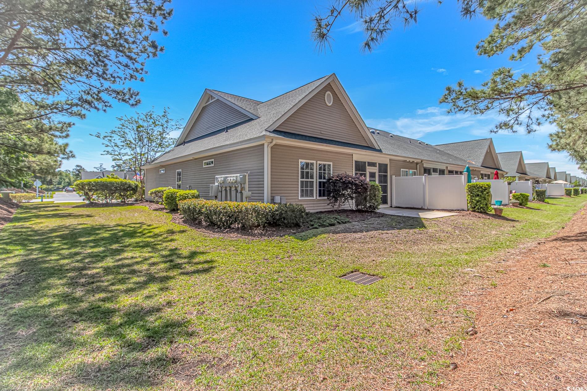 139 Chenoa Drive, Unit D Murrells Inlet, SC 29576 - Photo 2 of 34 View of side of property with a lawn, a shingled roof, and fence