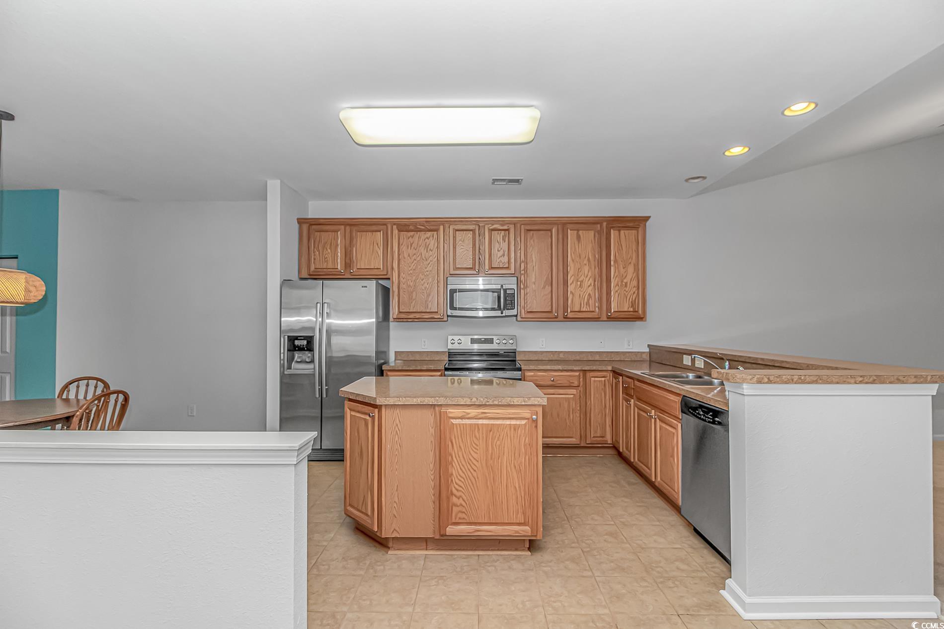 139 Chenoa Drive, Unit D Murrells Inlet, SC 29576 - Photo 6 of 34 Kitchen with a peninsula, appliances with stainless steel finishes, a kitchen island, light countertops, and recessed lighting