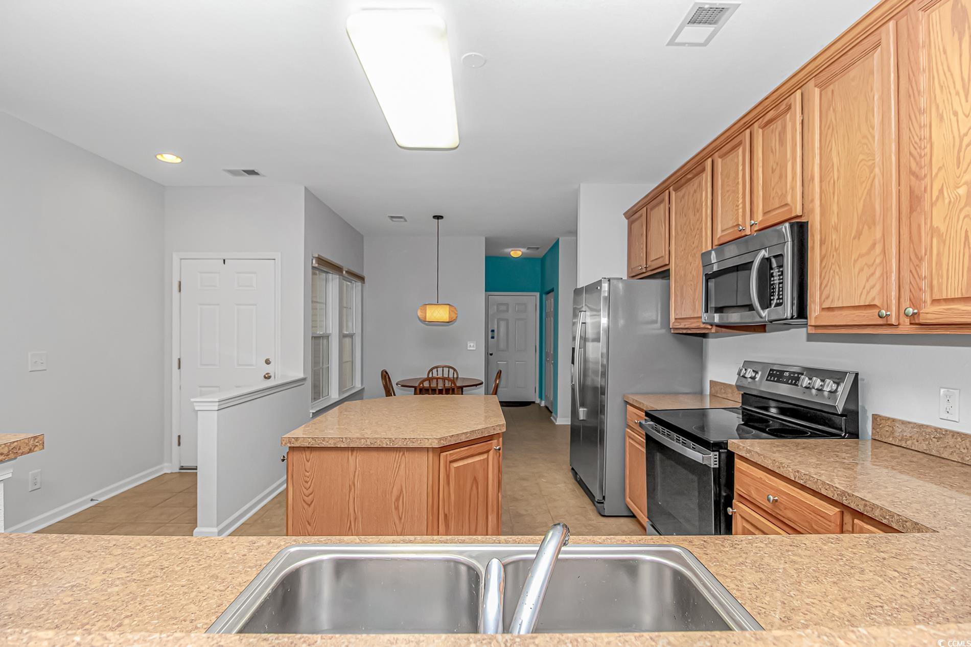 139 Chenoa Drive, Unit D Murrells Inlet, SC 29576 - Photo 8 of 34 Kitchen with stainless steel appliances, a center island, light countertops, pendant lighting, and light brown cabinetry