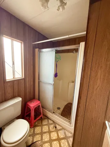 a bathroom with a toilet and a shower