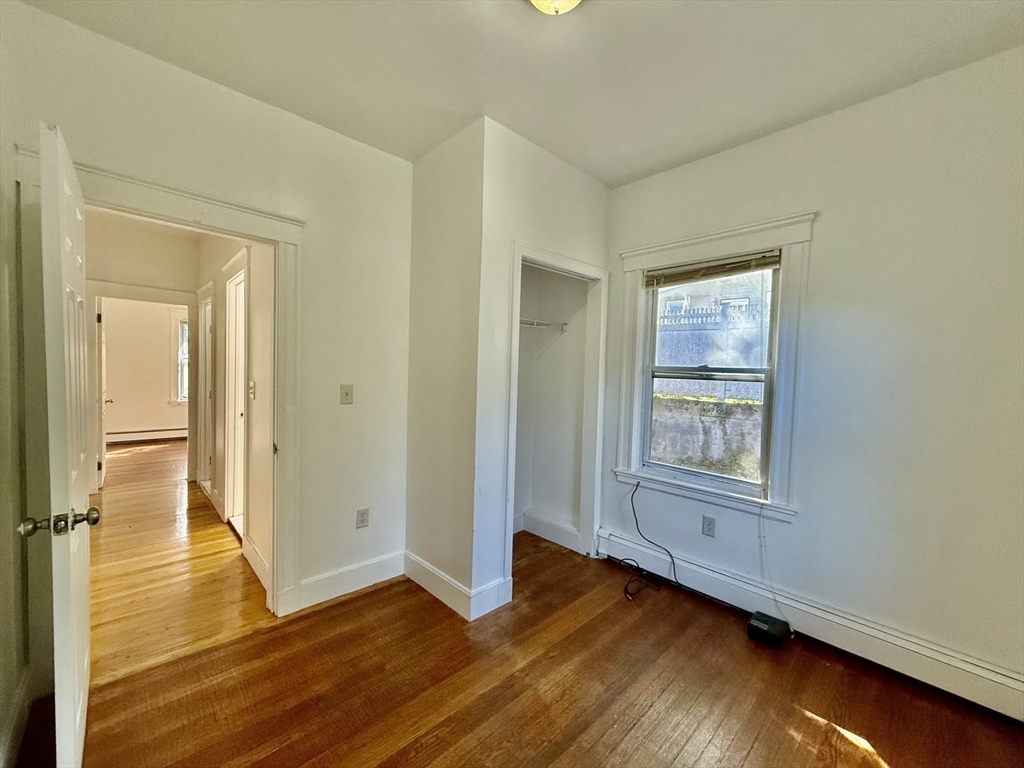 62 Algonquin Road, Unit 2 Newton, MA 02467 - Photo 28 of 38 an empty room with wooden floor and windows