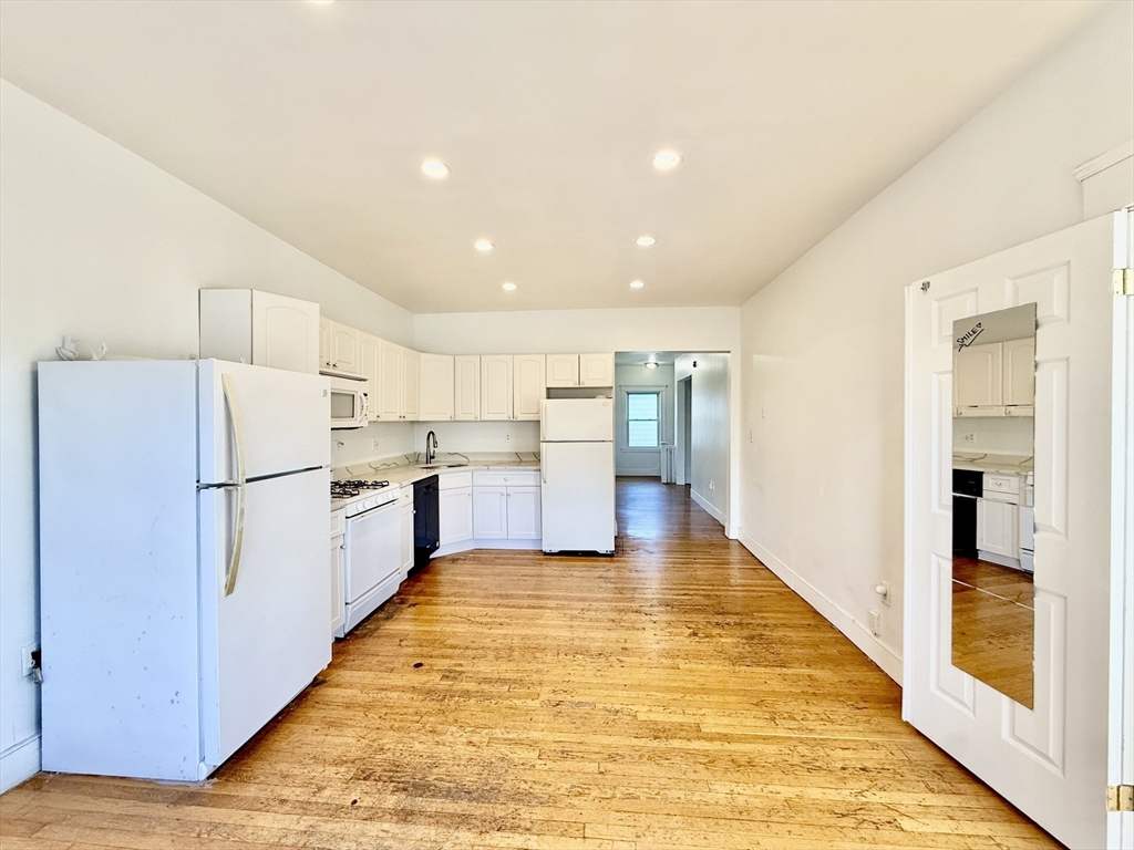 62 Algonquin Road, Unit 2 Newton, MA 02467 - Photo 6 of 38 a kitchen with stainless steel appliances a refrigerator and wooden floor