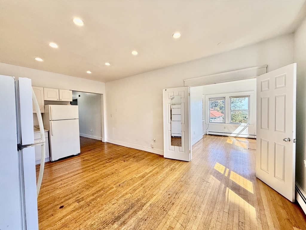 62 Algonquin Road, Unit 2 Newton, MA 02467 - Photo 7 of 38 a view of empty room with wooden floor and window