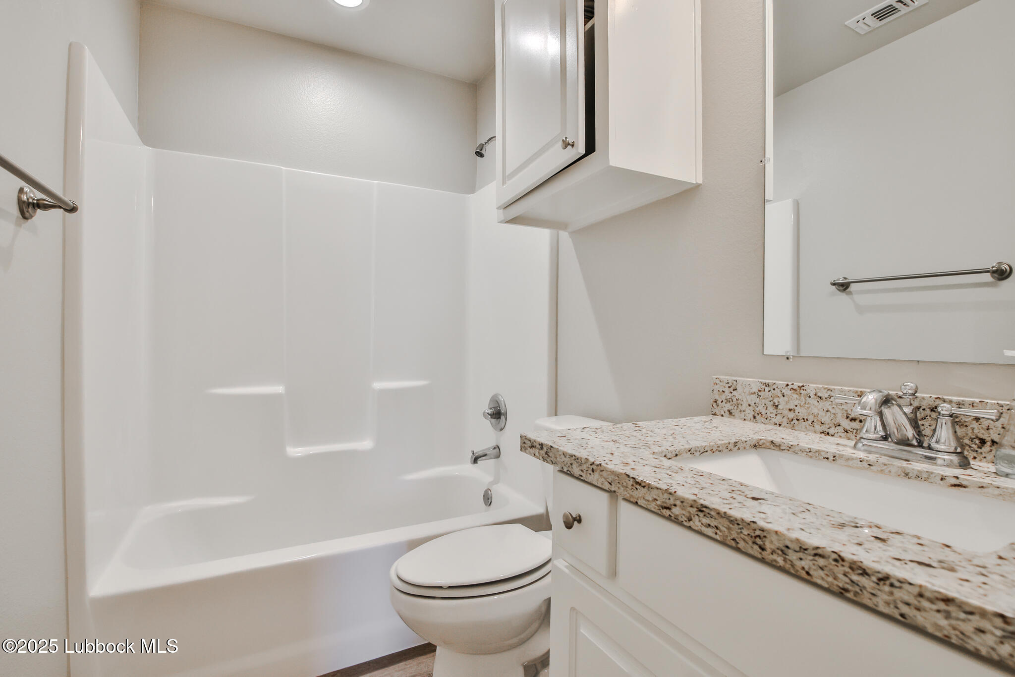 5221 Jarvis Street Lubbock, TX 79416 - Photo 5 of 22 a bathroom with a granite countertop sink a toilet and bathtub
