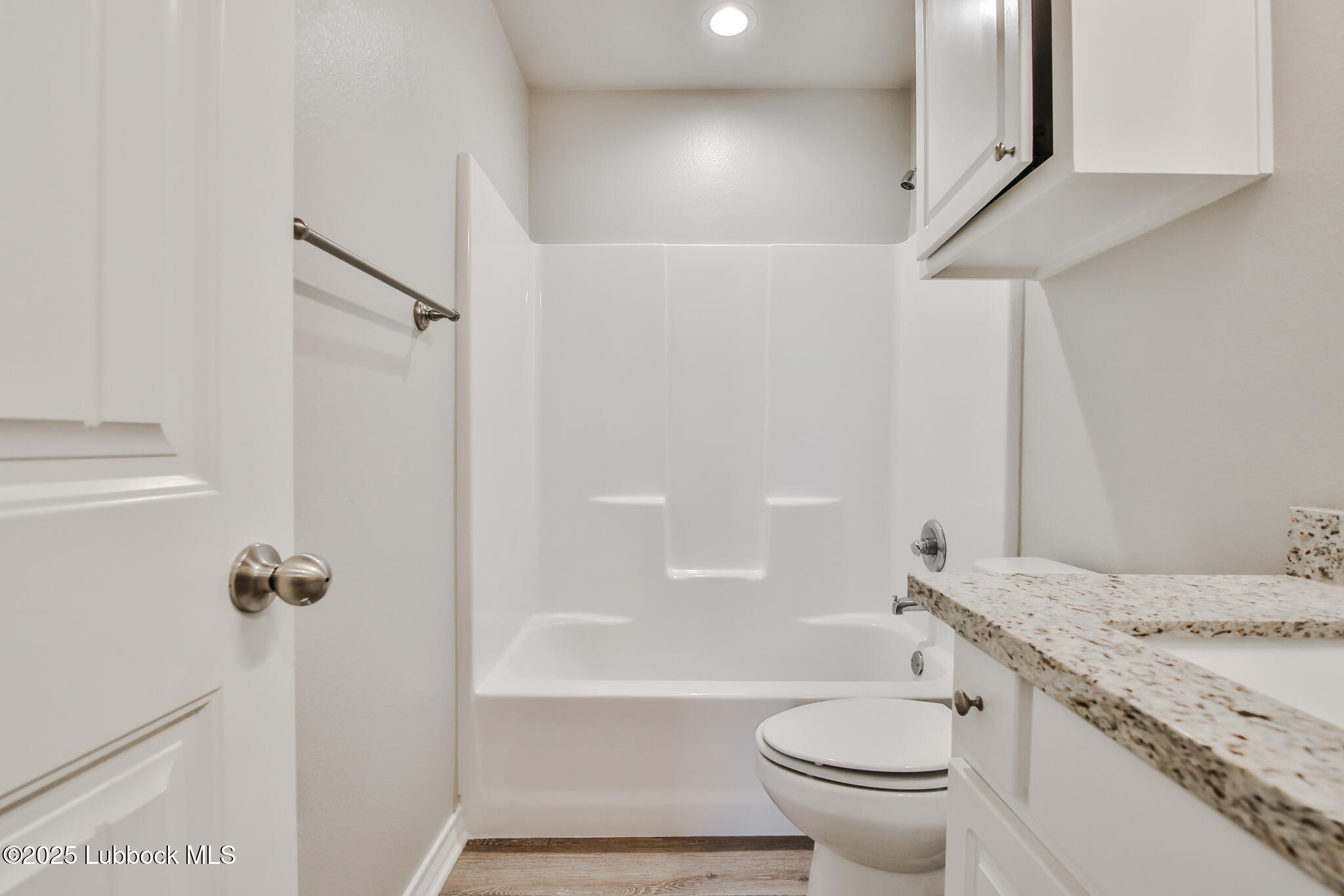 5221 Jarvis Street Lubbock, TX 79416 - Photo 6 of 22 a bathroom with a granite countertop sink toilet and shower