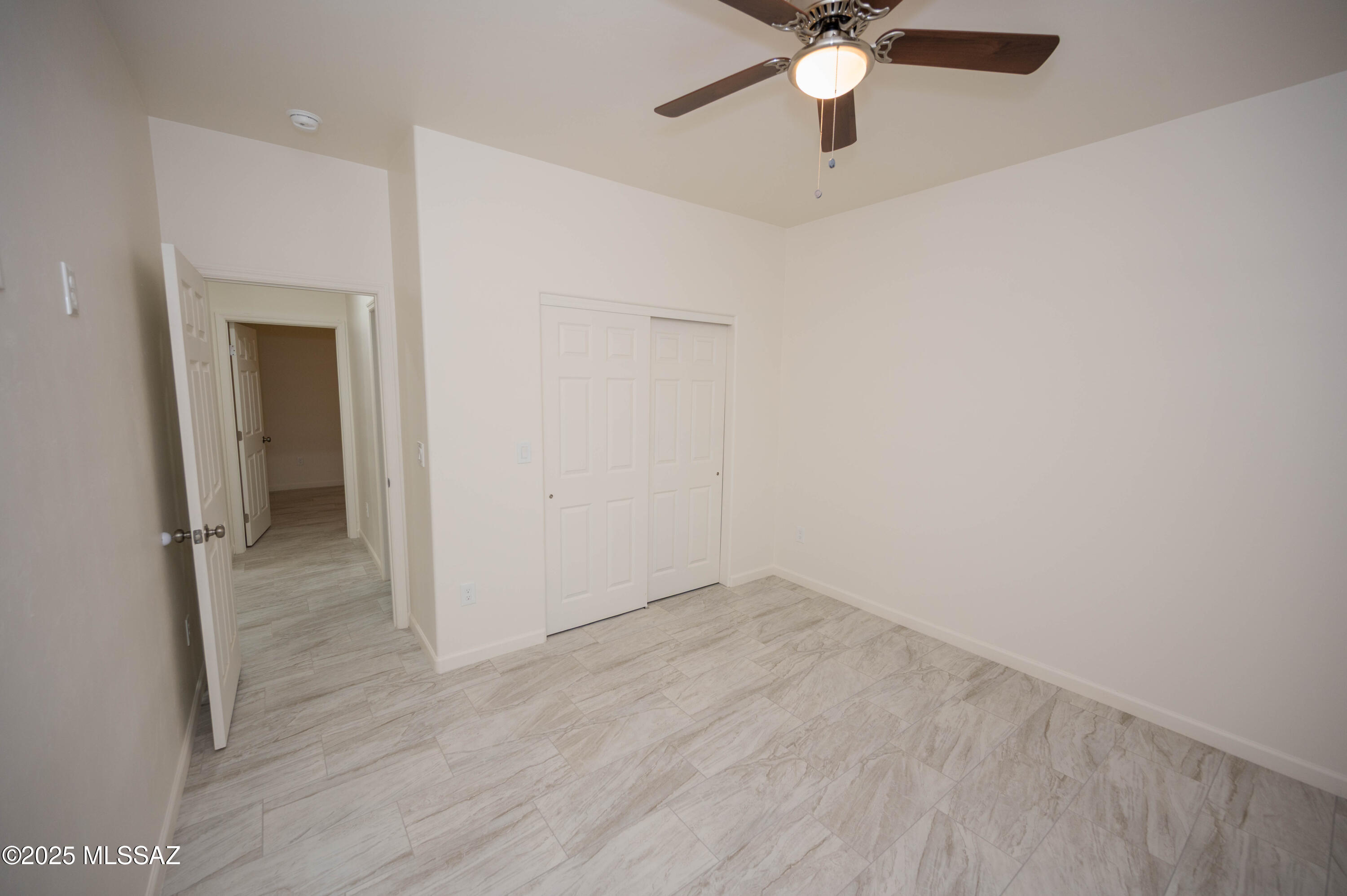 497 Calle Cipres Rio Rico, AZ 85648 - Photo 32 of 50 wooden floor in an empty room with a chandelier fan