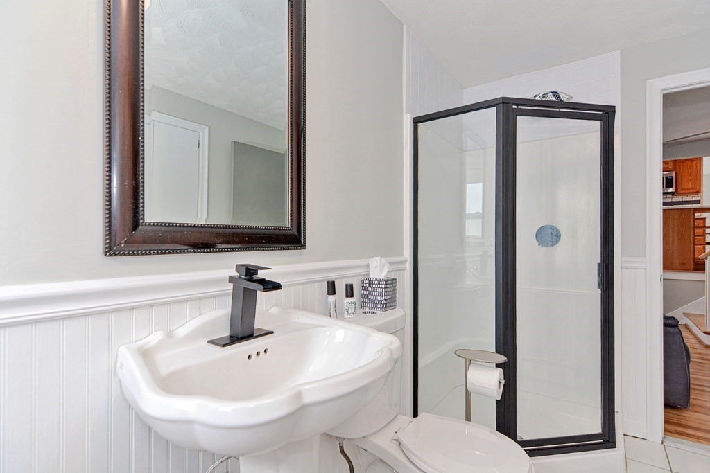 9 Doane Road Medford, MA 02155 - Photo 13 of 28 a bathroom with a sink a mirror a toilet and shower